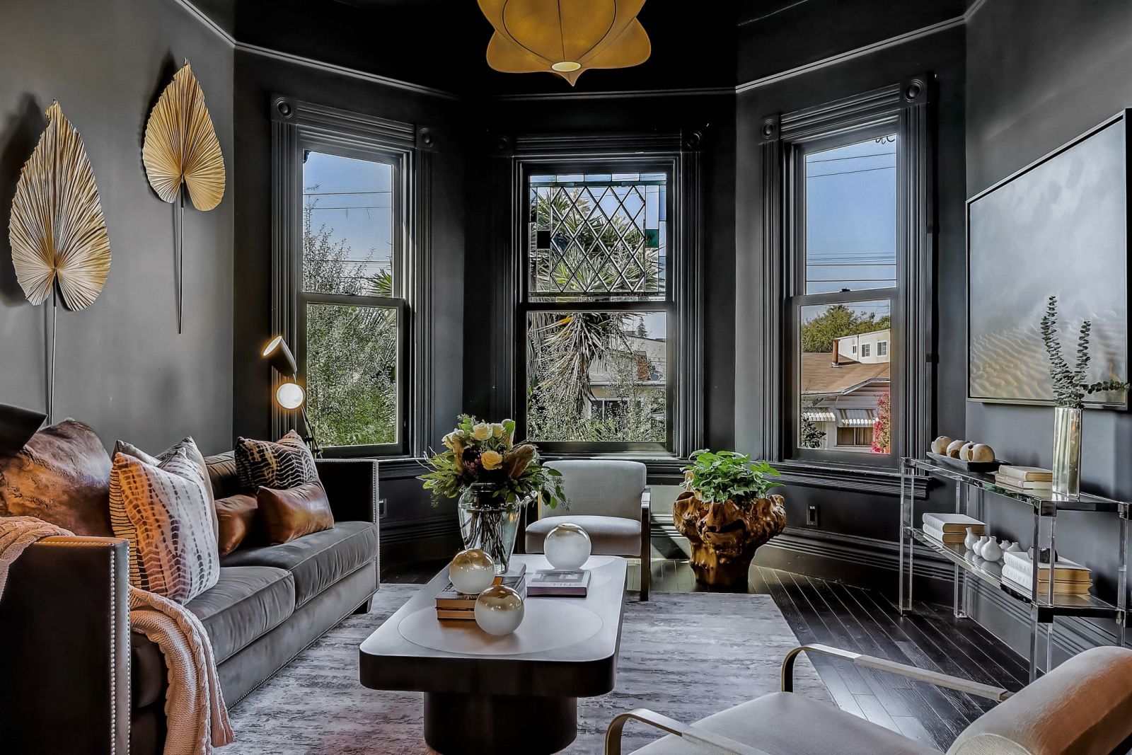 Interior of a Victorian house with painted black walls and a bay window.